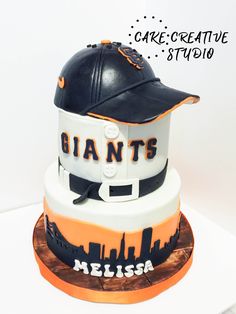 a cake that is shaped like a baseball hat and helmet with the word giants on it