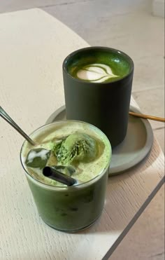 there is a green drink with ice cream in it and a spoon next to it