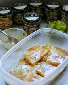 some food is in a plastic container on a table next to other foods and condiments