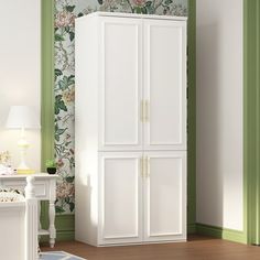 a bedroom with green walls and floral wallpaper on the walls, two white cupboards next to a bed