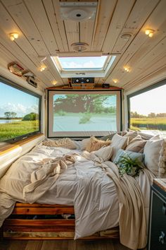 a bed in the middle of a room with two windows and a screen on the wall