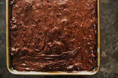 a pan filled with chocolate frosting sitting on top of a counter