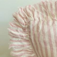 a pink and white striped dress with ruffles on the bottom, sitting on a table