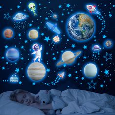 a child's bedroom with an outer planets wall decal and glow in the dark stickers