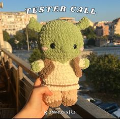 a hand holding a stuffed animal in front of a cityscape with the words tester call on it