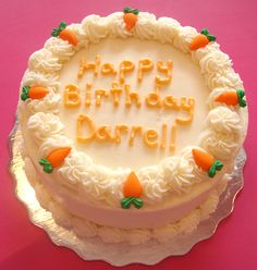 a birthday cake with white frosting and carrots