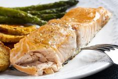 a white plate topped with salmon and asparagus