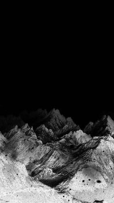 a black and white photo of mountains in the night with no one on it,