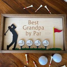 a wooden sign that says best grandpa by par with golf balls and tees