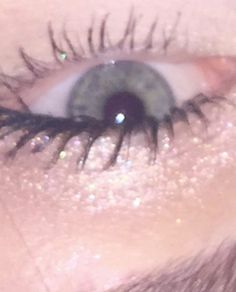 the eye of a woman with glitter on her lashes