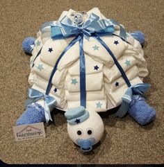 a stuffed turtle with a blue ribbon around it's neck and head is laying on the ground