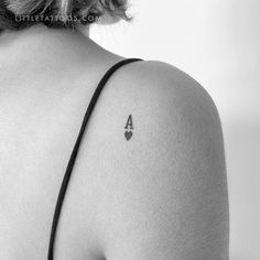 the back of a woman's shoulder with a small triangle tattoo on her left arm