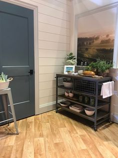 a room with a table, chair and pictures on the wall above it that is decorated with plants