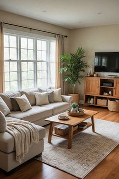 a living room filled with furniture and a flat screen tv on top of a wooden table