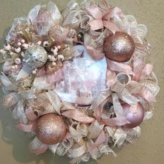 a wreath with pink and gold ornaments on it