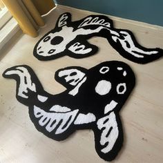 two black and white rugs on the floor in front of a door with an animal design