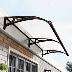 an awning on the side of a building with windows and potted plants outside