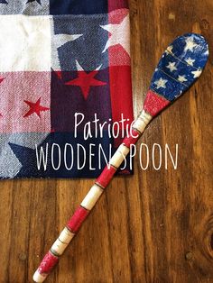 a patriotic wooden spoon sitting on top of a table next to an american flag napkin