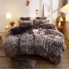 the comforter is made with grey fur and has two pillows on top of it