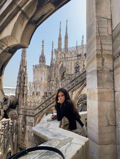 a woman standing on top of a stone building