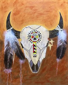 a painting of a bull's skull with feathers hanging from the side and an arrow painted on it