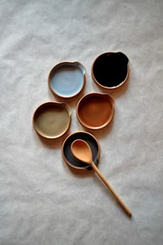 four bowls with spoons in them sitting on a table