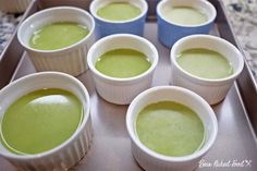 six cups filled with green liquid sitting on top of a tray