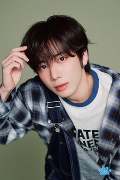 a young man is posing with his hands on his head and looking at the camera