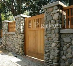 a stone fence with wooden gates and benches