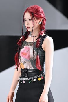 a woman with red hair and braids on the runway