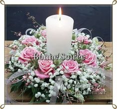 a bouquet of pink roses and white baby's breath with a lit candle