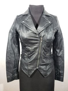 Cute women's leather jacket with a metal zipper. Women's black leather jacket. The jacket is made of durable black genuine leather. The jacket is easily fastened with a metal zipper. There are two pockets at the bottom of the jacket that close with a metal zipper and two at the top. The jacket has decorative rivets. The jacket has decorative laces on the sleeves and on the back. the cuffs of the jacket have metal snaps. The corners of the collar have metal snaps to which they can be fastened. On Womens Black Leather Jacket, Leather Biker Jacket, Black Leather Jacket, Leather Jackets Women, Cute Woman, Soft Black, Biker Jacket, Leather Women, Black Leather