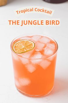 the jungle bird cocktail is garnished with an orange slice