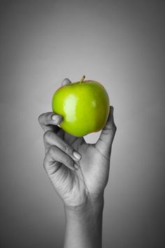 a person holding an apple in their hand