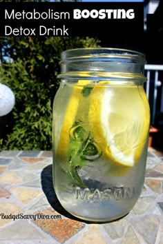 a mason jar full of water with lemons and mint on the outside patio table