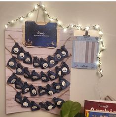 a bulletin board that has some little blue birds on it and lights strung up behind it