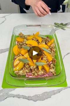 a green tray with food in it on top of a white tableclothed surface