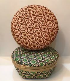 two round boxes sitting on top of each other