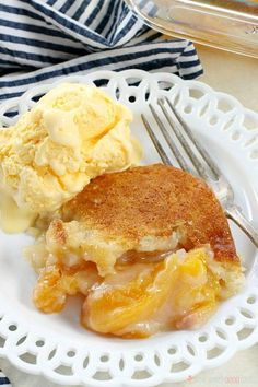 a white plate topped with an apple cobbler and ice cream next to a fork