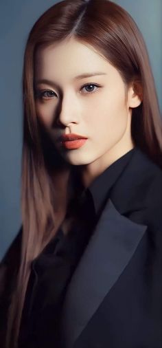 a woman with long brown hair wearing a black shirt and blazer, posing for the camera