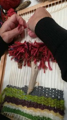 two hands are working on an art project with yarn and scissors in front of them