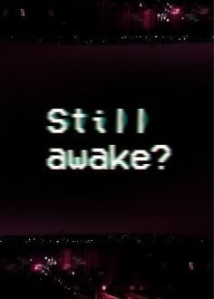 the words still awake are projected in front of a dark cityscape at night