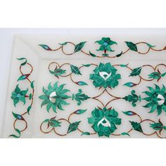 a white tray with green flowers and leaves on it