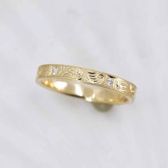 a yellow gold wedding ring with diamonds on the inside and outside, set against a white background