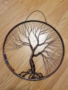 a metal wire tree sculpture sitting on top of a wooden floor