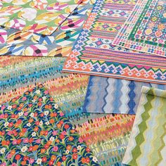 many colorful fabrics are laid out on the ground