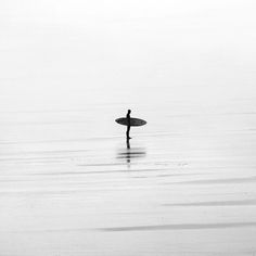 a person standing in the water with a surfboard