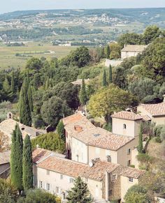 an aerial view of some buildings and trees in the distance with hills in the background