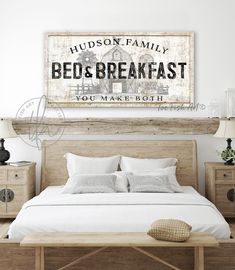 a bed with white sheets and pillows under a wooden sign that reads hudson family bed & breakfast you make both