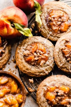 apples and cookies on a cooling rack next to two peaches, one with powdered sugar